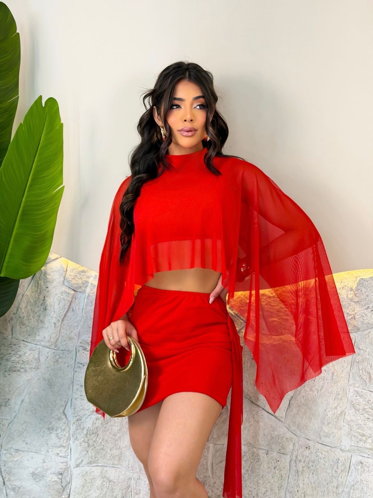 Modelo da Amanda Ramos Store com conjunto vermelho e mangas amplas